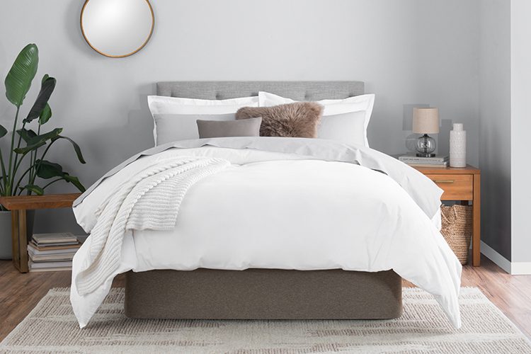 A beautifully made bed featuring a modern Circa Bed Wrap in the color SmokeyQuartz.