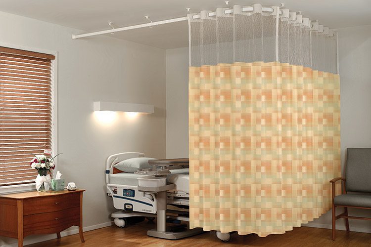 On The Right Track Privacy Curtains shown in the pattern Blocks in color-way Tahiti are shown hanging around a bed in a hospital room.