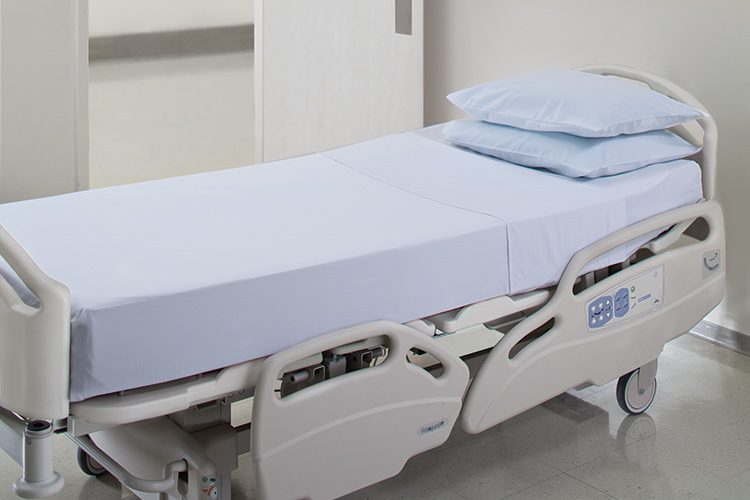 A patient bed with sheets and two pillows.