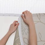 Hands snapping a removable healthcare / hospital privacy curtain into place.