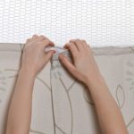 Hands showing the final step in replacing a privacy curtain.