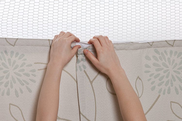 Hands showing the final step in replacing a privacy curtain.
