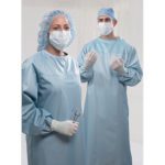 Two doctors prepared for surgery wearing surgical gowns, masks, gloves, and hair protection.