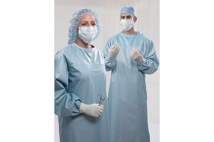 Two doctors prepared for surgery wearing surgical gowns, masks, gloves, and hair protection.