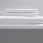 a stack of two pillowcases and two sheets for motels in single pick percale