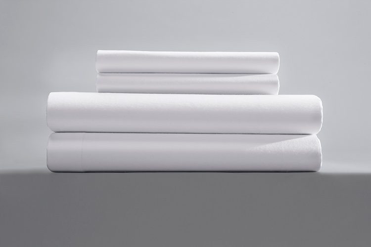 a stack of two pillowcases and two sheets for motels in single pick percale