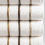 Stack of white pool towels with brown and beige stripes.