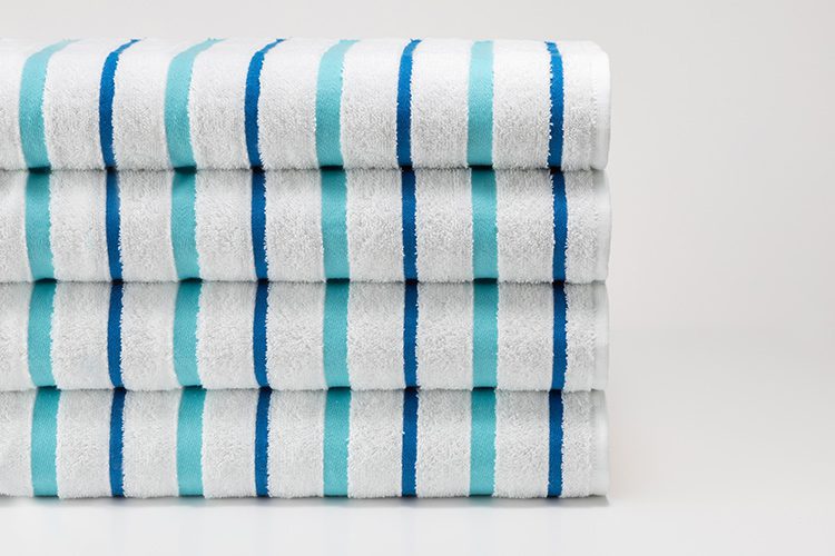A folded stack of Seaglass Stripe Pool Towels.