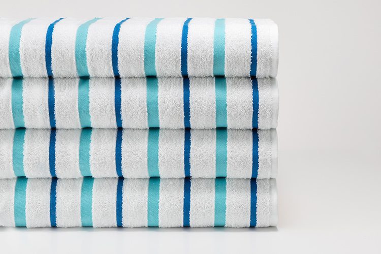 A folded stack of Seaglass Stripe Pool Towels.