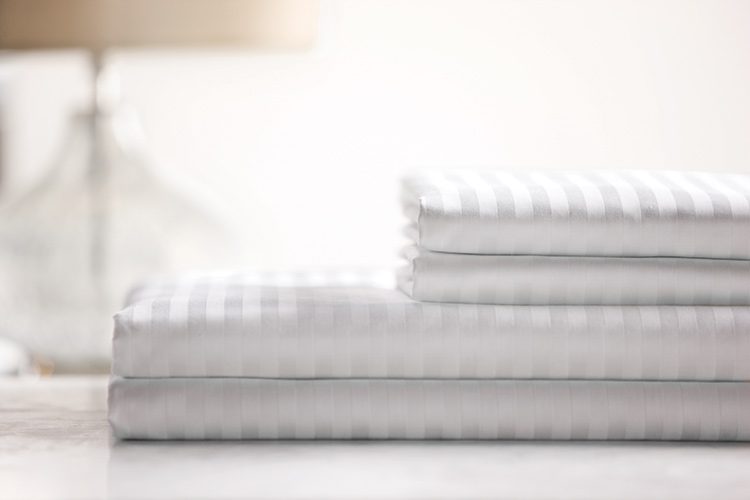 Stack of T300 100% cotton sheets with woven stripes..