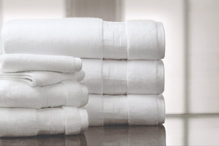 A stack of white TAL Braque Terry Towels, handtowels and washtowels.
