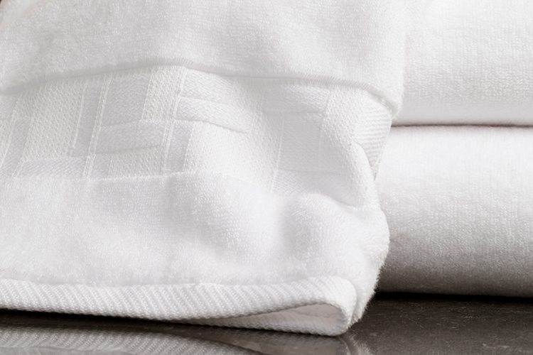 A stack of towels showing the unique TAL Braque terry cam border.