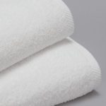 A detail image of a stack of white Transitions terry towels.
