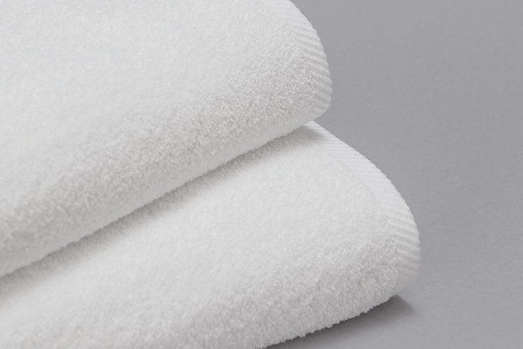 A detail image of a stack of white Transitions terry towels.