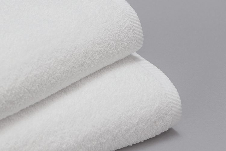 A detail image of a stack of white Transitions terry towels.