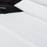 Pillow and bed dressed with luxury Vidori sheets for hotels