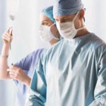 Two medical professionals wearing ComPel® surgical apparel. These medical gowns are designed to provide healthcare professionals the ultimate performance in breathable, reusable products.