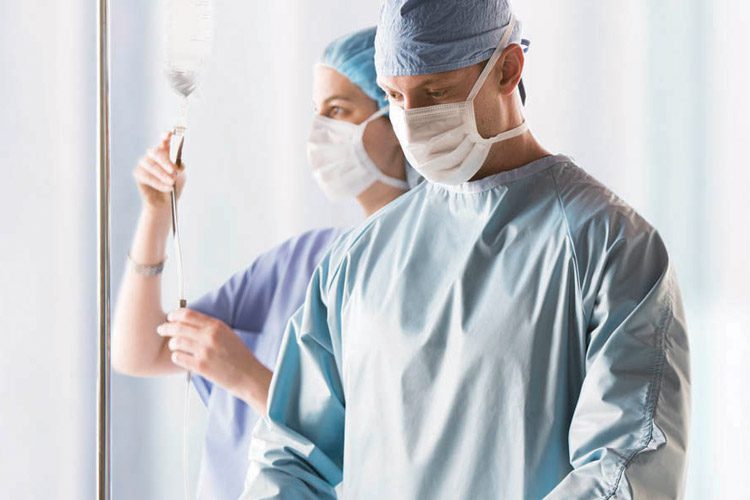 Two medical professionals wearing ComPel® surgical apparel. These medical gowns are designed to provide healthcare professionals the ultimate performance in breathable, reusable products.