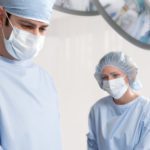 Two surgeons wearing blue Compel Surgical Gowns.