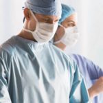 Two medical professionals wearing ComPel® surgical apparel. These medical gowns are designed to provide healthcare professionals the ultimate performance in breathable, reusable products.