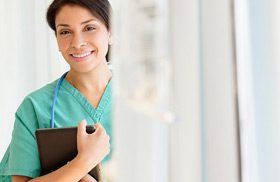 A female doctor holding a clipboard, stands slight behind a set of cubical curtains.