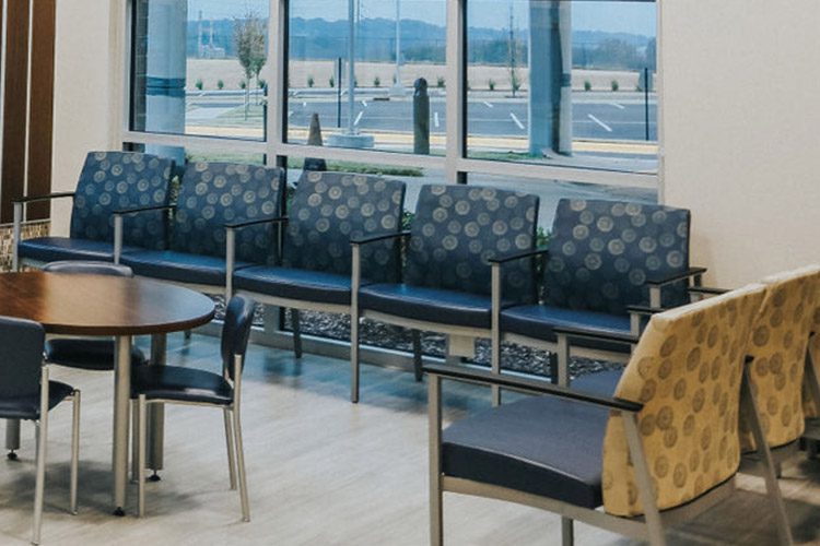 A hospital waiting room with chairs in a beautiful circular blue Pattern is seen here.