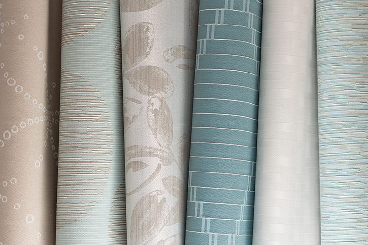 Several pieces of fabric in a variety of colors and patterns, stacked next to each other.