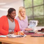 Two Standard Textile team members review fabric swatches featuring various pattern and color options.