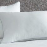 Two AllerEase Ultimate Pillows rest against a grey headboard.