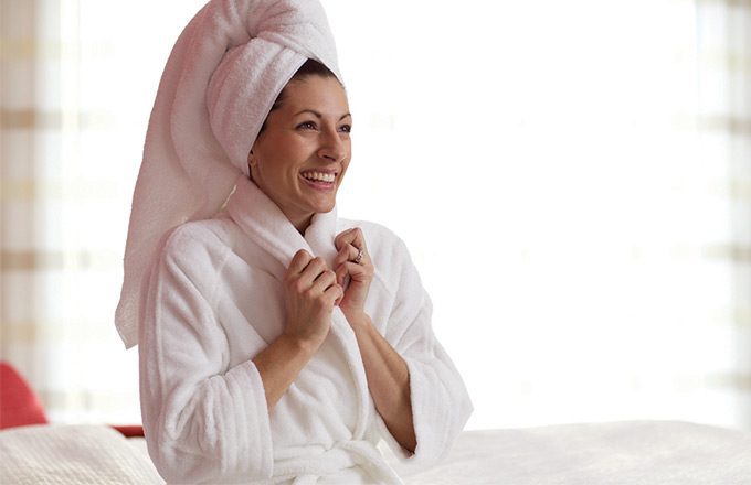 A happy guest relaxing in a luxurious bath robe