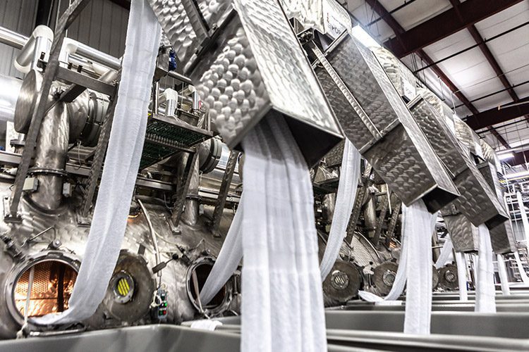 A large machine used to pre-launder long stretches of uncut, unfinished linens.