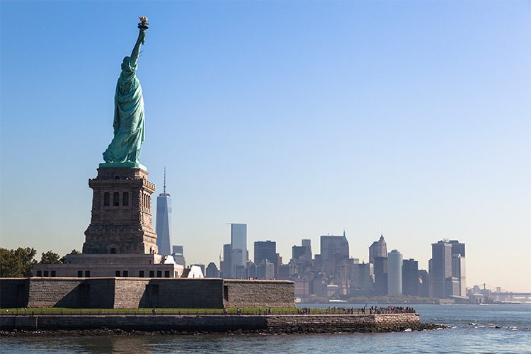 A photo of the Statue of Liberty, some of the New York City skyline can be seen in the background.