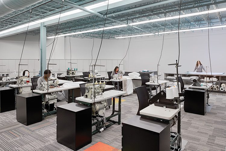 A behind the scenes view into our Prototype Production Center, featuring several team members working at sewing machines.