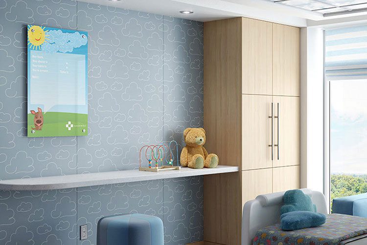 The image is of a Clarus Board with a fun cartoon graphic behind the glass. It is a pediatric hospital room.