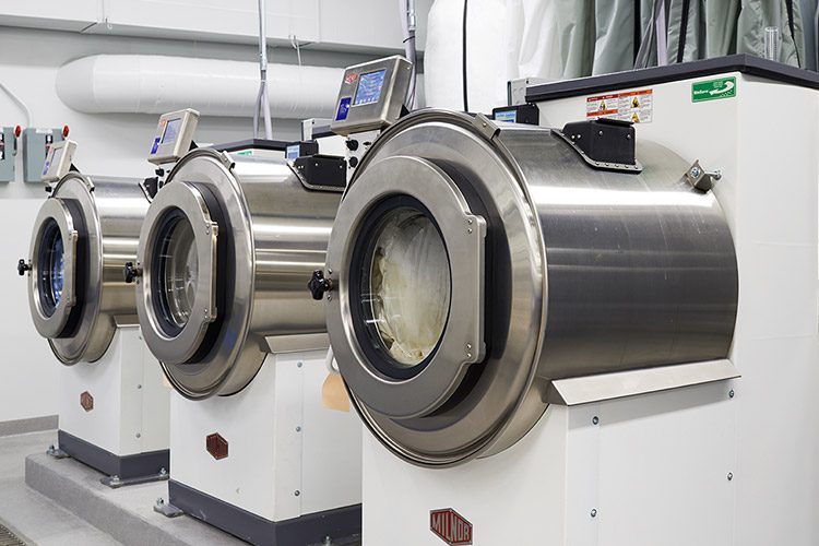 Three industrial washing machines.