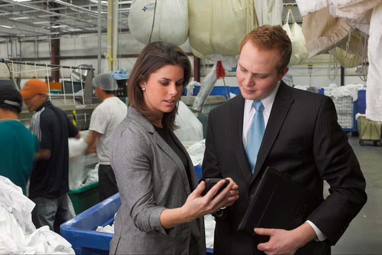 Two people in business attire standing in a laundry facility.