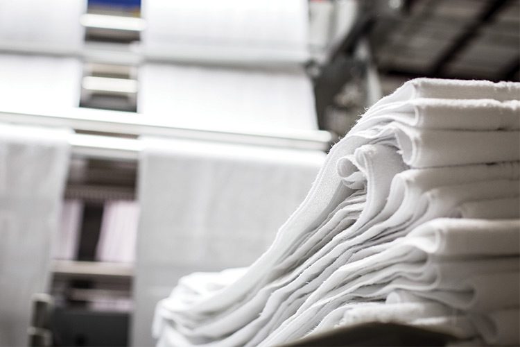A detail shot of a pile of unfinished linens during the manufacturing process.