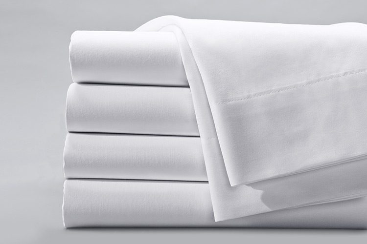 A Centima sheet draped over a folded stack of Centima sheets.