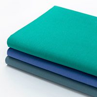 stack of dyed healthcare sheets in assorted colors