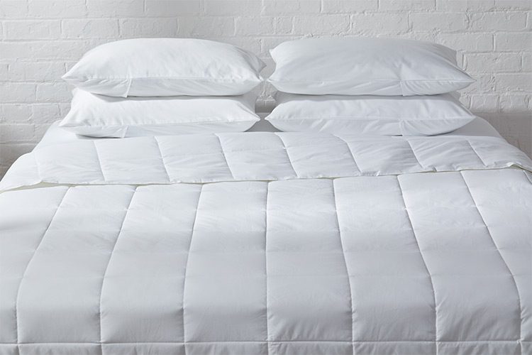 A hotel bed featuring an Innerloft hotel comforter duvet insert.