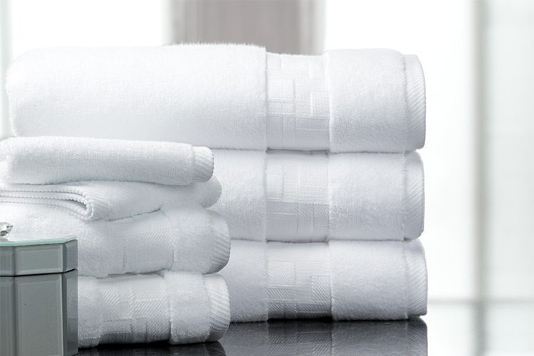 Two stacks of folded Todd Avery Lenahan Braque bath towels.