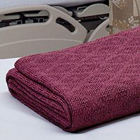 Hospital blanket Thermo Plus® folded and laying on a hospital bed | Healthcare Blankets & Spreads