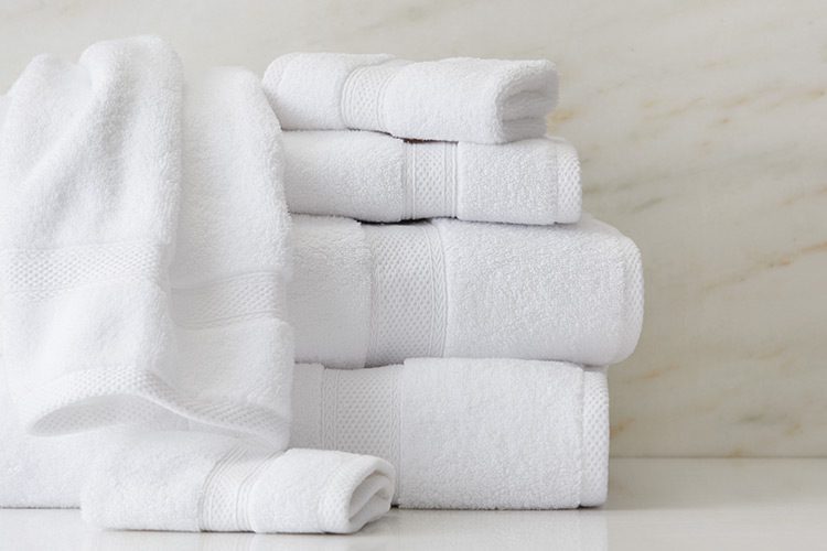 A folded stack of white hospitality towels.