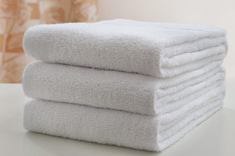 A stack of three white folded towels.