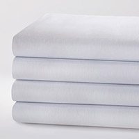 Image of a stack of folded TruVal® sheets. Our patented TruVal® sheets provide an exceptional patient experience due to the twill weave and high cotton content of our sheets and pillowcases.