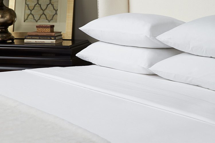 A well-made luxury hotel bed featuring Vidori sheets.