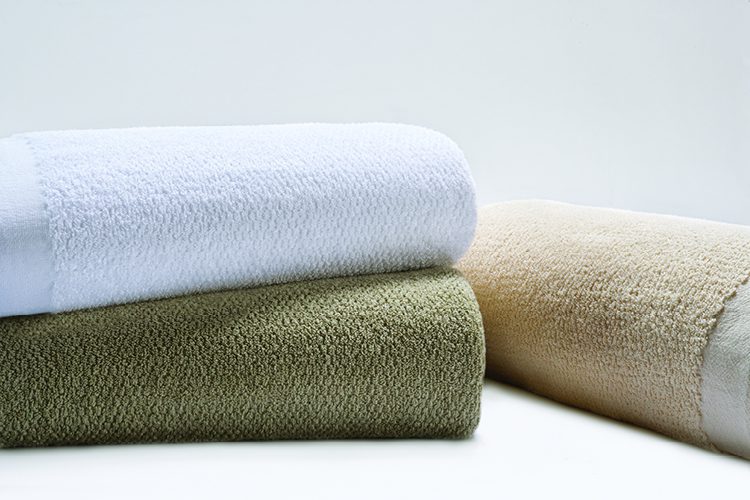 Stack of three hospital blankets & bedspreads.