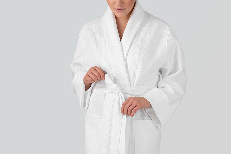 A woman wearing a Logan Waffle hotel robe.