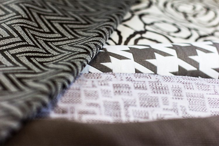 Several fabrics folded and laid across one another, each a unique pattern and color.