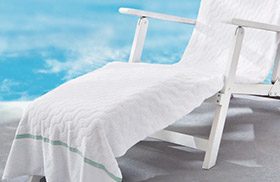 pool towel draped over poolside lounge chair